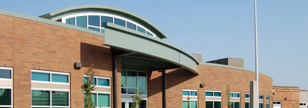 Brick public building with a curved entrance canopy and arched windows.