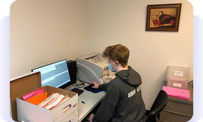 Employee working at a computer in a small records office.