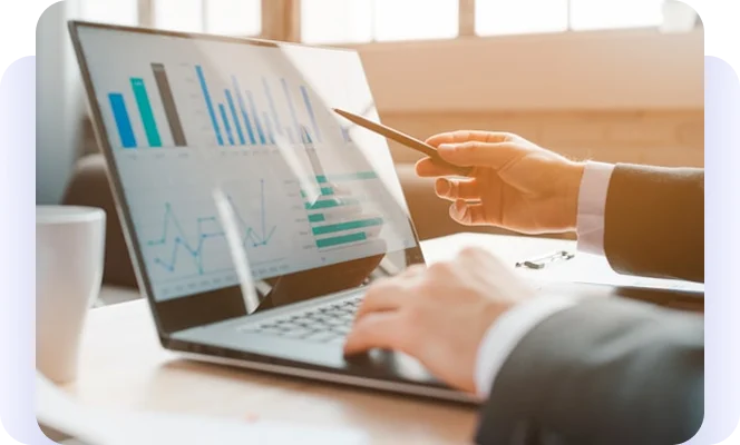 Business professional reviewing charts and graphs on a laptop.