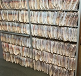 Rows of hanging paper or material samples on storage racks.